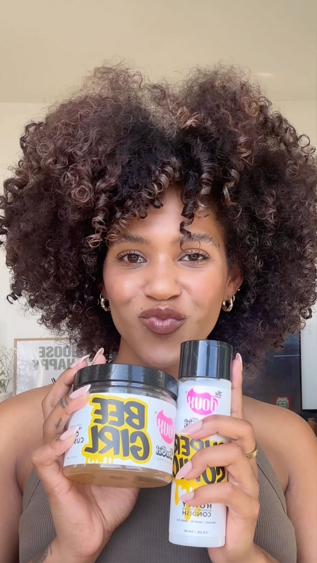Diliana van Rijn met volle krullen toont The Doux Bee Girl Curl Hydration producten – gel en conditioner voor krullend haar online kopen bij Beauty Source.