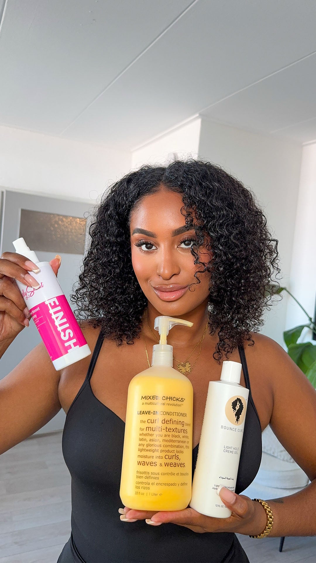 Lakeysha Dhanai met krullend haar toont haarverzorgingsproducten van Curly Secret, Mixed Chicks en Bounce Curl – leave-in conditioner en styling gel voor krullen online kopen bij Beauty Source.